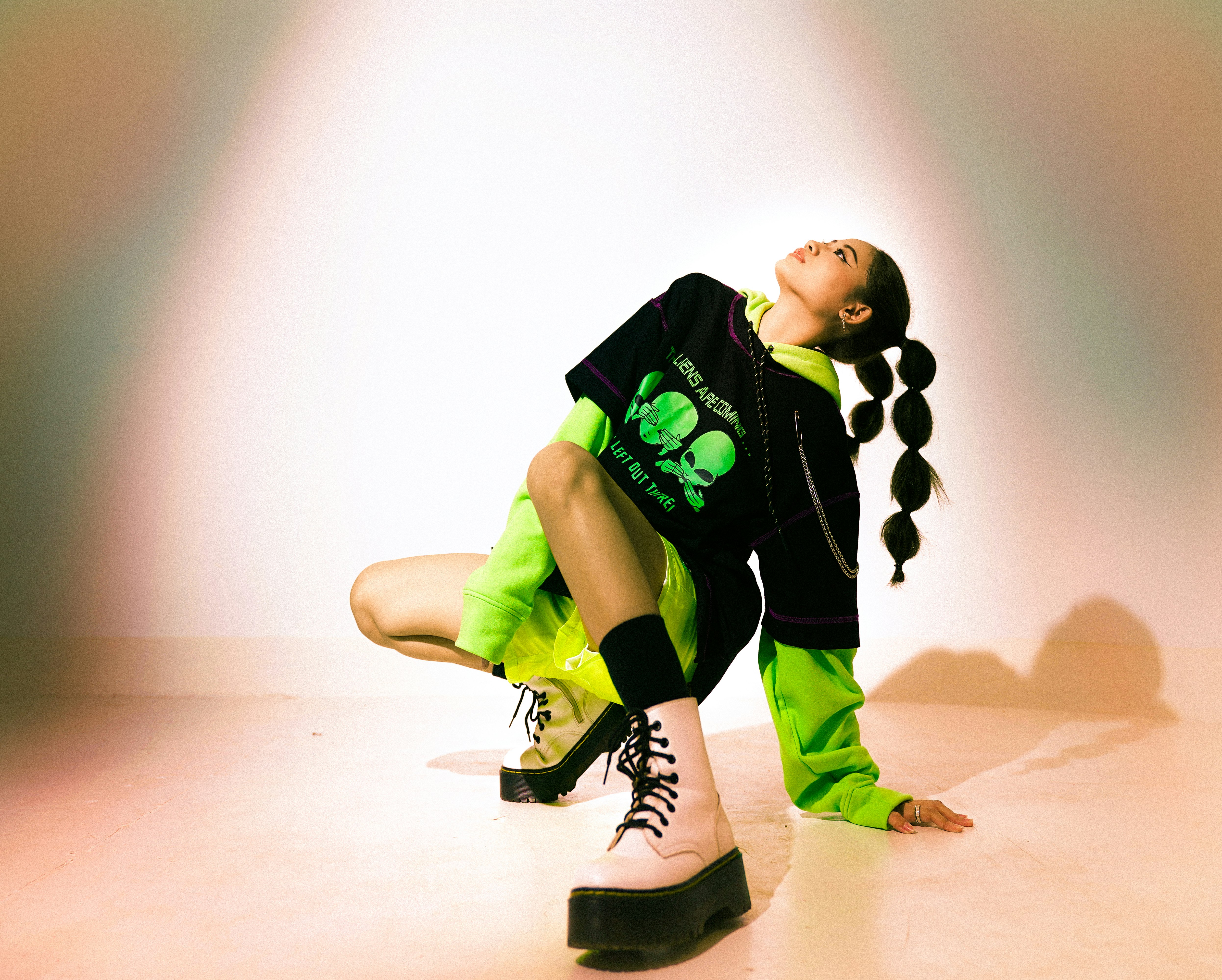 boy in black and green t-shirt and black pants sitting on floor